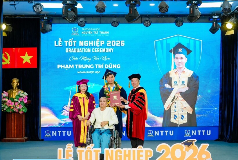 Đại diện Ban Giám hiệu Trường ĐH Nguyễn Tất Thành trao bằng tốt nghiệp loại Xuất sắc cho Trí Dũng trong buổi lễ tốt nghiệp. (Ảnh: Trường ĐH Nguyễn Tất Thành).