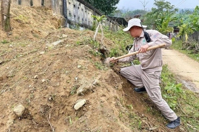 Lực lượng chức năng tìm cách xử lý quả bom chùm gần khu vực trường học. Ảnh: Dân trí