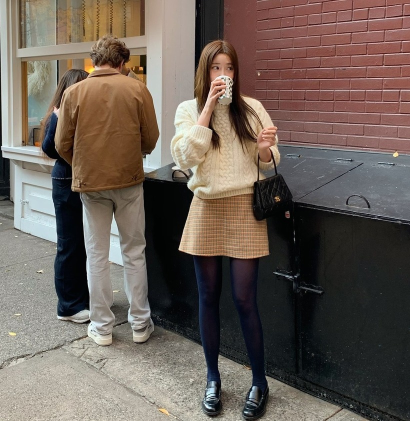 Một chiếc áo len trắng hay màu kem kết hợp với chân váy chữ A xếp ly màu nâu sẽ càng khiến cho nàng thêm xinh.