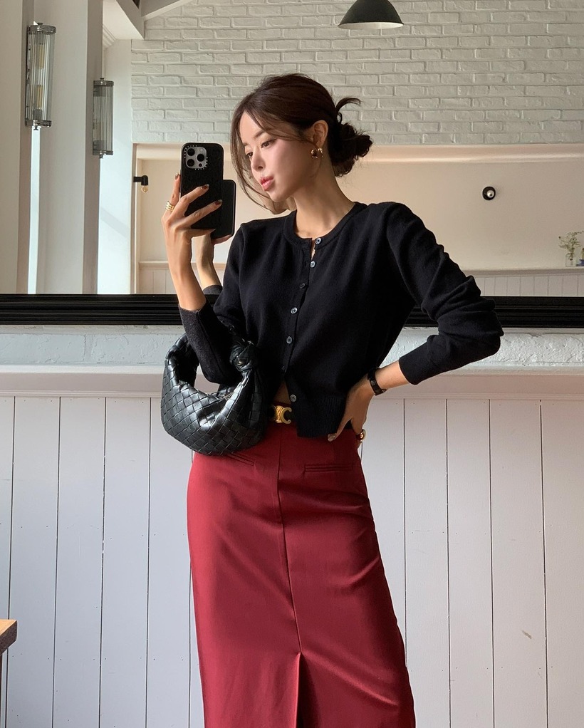 Bên cạnh áo, các mẫu chân váy mang tông màu đỏ cũng rất đáng sắm. Món thời trang này vừa mang lại sự nữ tính, vừa giúp vẻ ngoài thêm nổi bật, sang trọng. Vốn dĩ, chân váy màu đỏ đã hút mắt nên chị em chỉ cần kết hợp item này với áo cardigan màu đen, vậy là ghi điểm phong cách. Bộ đồ trên còn thích hợp để mặc đi làm, giúp style công sở của chị em thêm mới mẻ, đa dạng.