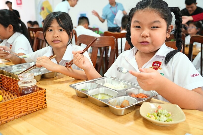 Học sinh tiểu học thưởng thức bữa trưa cân bằng dinh dưỡng từ thực đơn của Phần mềm Dự án Bữa ăn học đường.