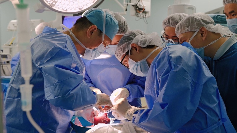 PGS.TS.BS Lê Văn Thành cùng ê-kíp đang tinh chỉnh lại mảnh gan hiến từ người mẹ trước khi ghép cho bé.