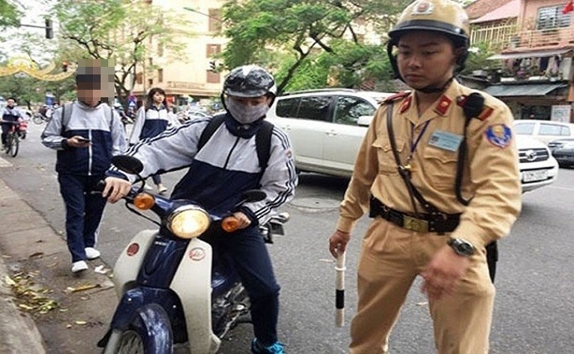 Cảnh sát giao thông kiểm tra một học sinh vi phạm. (Ảnh min họa: Lao động)