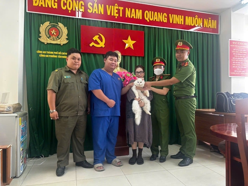 Chị Huỳnh Thị Kim Quyên vui mừng khi nhận lại con mèo Tiểu Bạch. (Ảnh: Công an phường Tân Hưng).