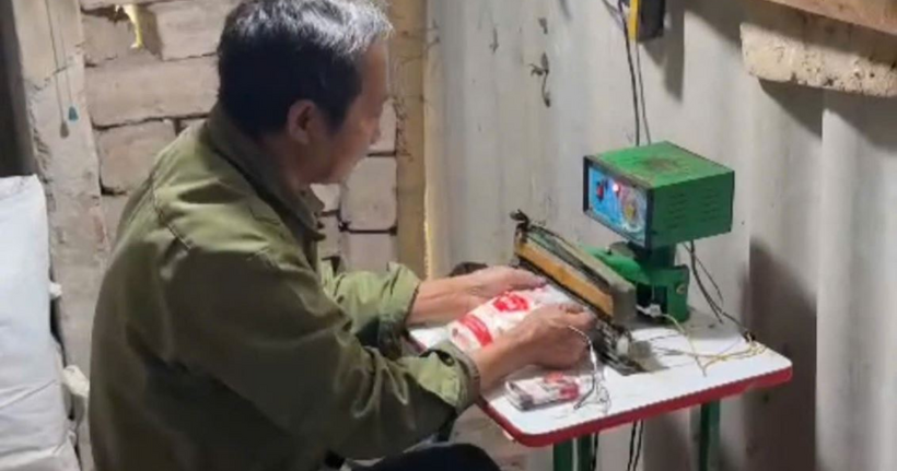 Hình ảnh đối tượng đang tiến hành thực hiện việc đong, cân và đóng gói mì chính giả nhãn hiệu AJINOMOTO. (Ảnh: Công an Hưng Yên)