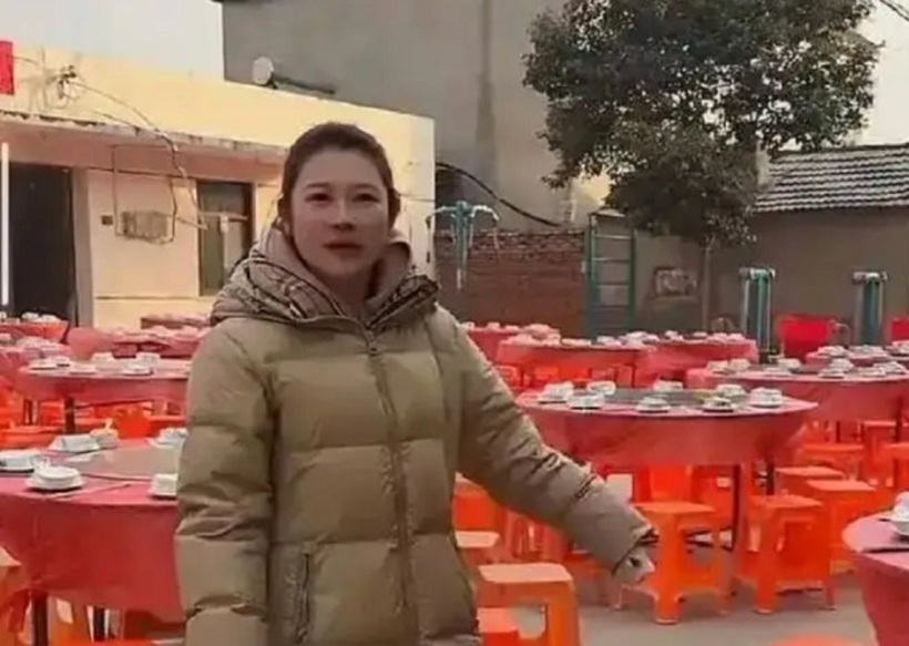 Cô gái ở tỉnh Giang Tô đứng cạnh 100 mâm cỗ đã chuẩn bị nhưng không ai đến ăn (Ảnh: 163.com).