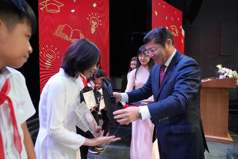 Ông Tsutomu Nara - Tổng giám đốc Công ty Ajinomoto Việt Nam trao quà tặng cặp sách cho các em học sinh.