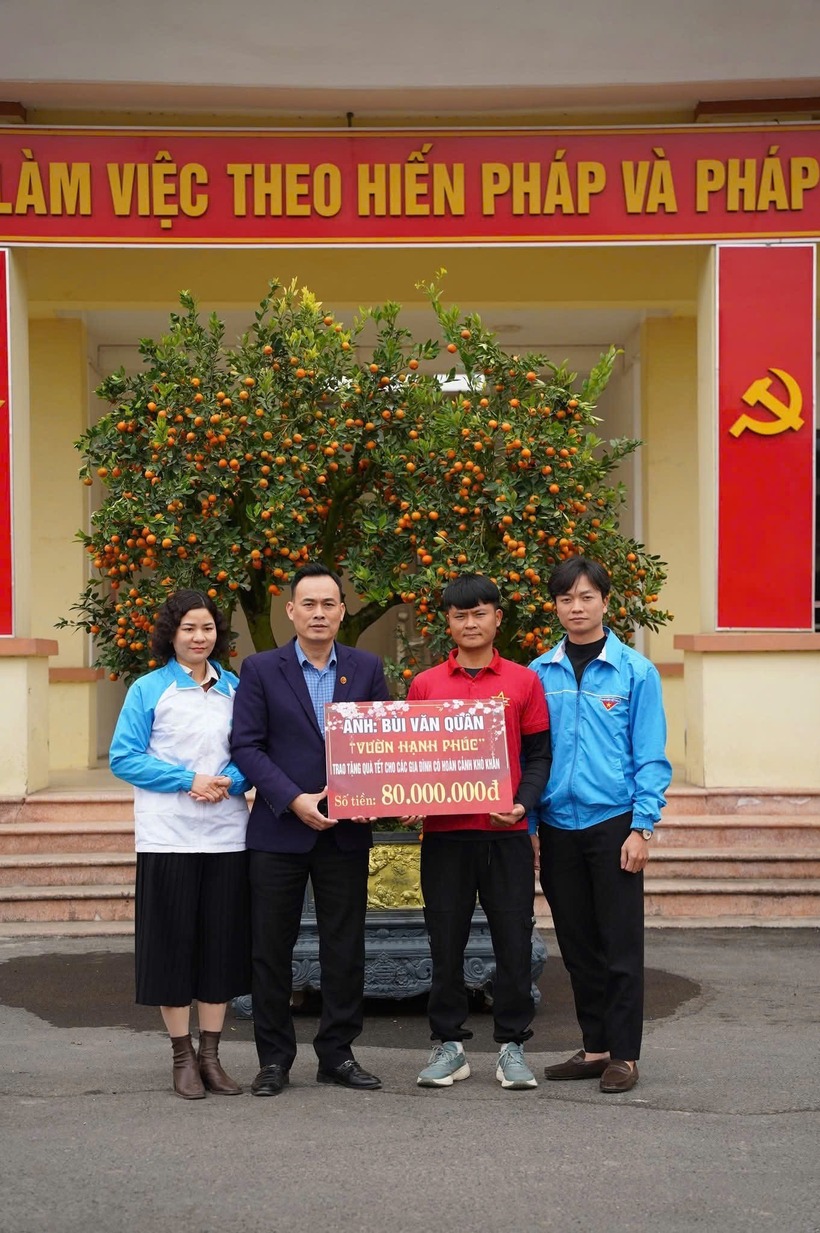 Anh Quân (áo đỏ) trao số tiền 80 triệu đồng cho xã Hợp Thịnh. Ảnh: Vietnamnet.