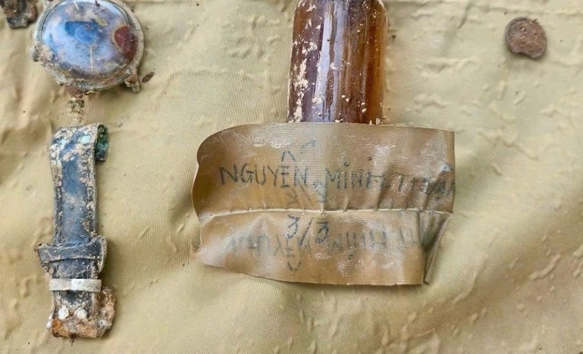 Mảnh giấy chôn cùng hài cốt liệt sĩ có tên. Ảnh: Lao động