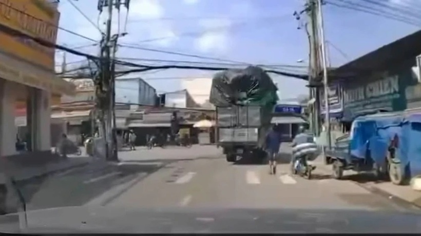 Xe tải chở hàng vướng dây điện làm rơi bao hàng trúng người đi đường. Nguồn clip: PLO