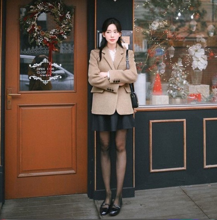 Quần short hoặc chân váy ngắn kết hợp quần tất đen tạo nên phong cách cá tính, hiện đại.