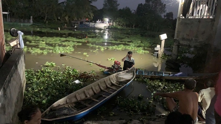 Người dân đang tìm kiếm bé gái bị mất tích dưới kênh Nguyễn Tấn Thành. Ảnh: Tuổi trẻ