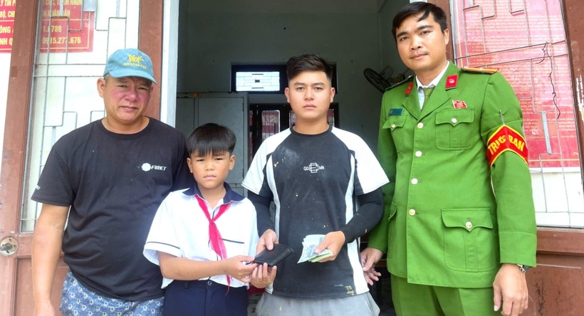 Em Thành cùng bố trao lại ví cho người đánh rơi. (Ảnh: Công an tỉnh Quảng Trị)