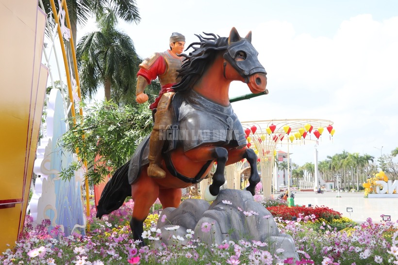 Bên cạnh đó, sự xuất hiện của mô hình Thánh Gióng cưỡi ngựa sắt là một điểm nhấn văn hóa đầy ý nghĩa. Bức tượng tái hiện hình ảnh vị anh hùng làng Gióng mặc áo giáp vàng, gương mặt cương nghị, tay cầm bụi tre ngà làm vũ khí, sẵn sàng xung trận bảo vệ non sông. Chú ngựa sắt đồng hành có màu nâu đỏ mạnh mẽ, được trang bị lớp giáp xám kiên cố, thể hiện ý chí quật cường của dân tộc. (Ảnh: Người lao động)