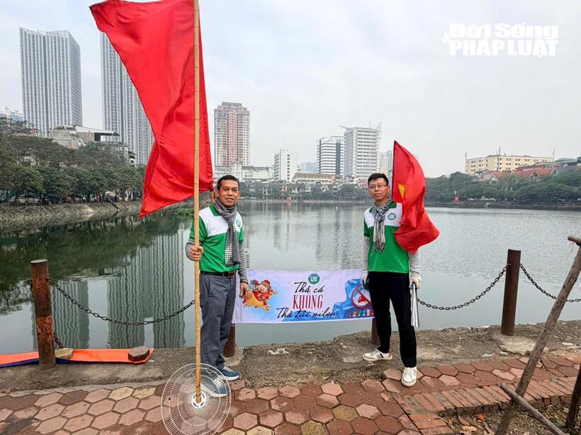 Các tình nguyện viên hỗ trợ người dân thả cá chép và thu gom rác thải quanh khu vực hồ.