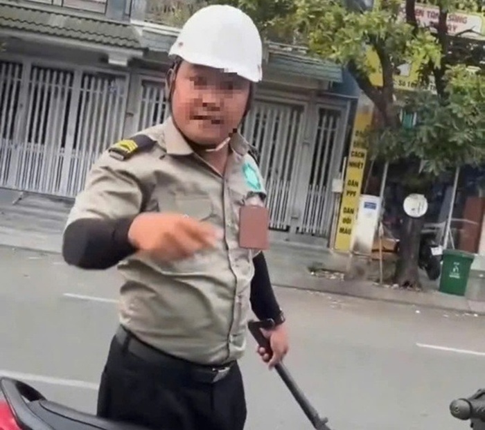 Người đàn ông mặc đồ bảo vệ đe dọa tài xế ô tô ở TP.HCM. Ảnh: Báo Sức khỏe và Đời sống.