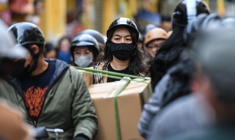 Dòng người “tay xách nách mang” rời khu phố cổ trong chiều 25 Tết, mỗi người đều mang theo các túi, thùng đồ ăn thức uống phục vụ ngày Tết.