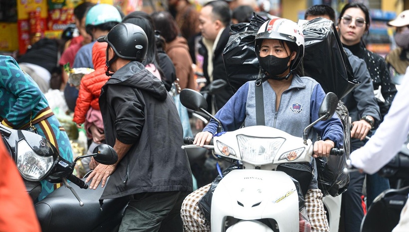 Nhiều shipper giao hàng làm việc liên tục, buộc dây, sắp xếp kiện hàng ngay trên yên xe rồi tìm cách thoát khỏi đoạn phố đông nghịt.