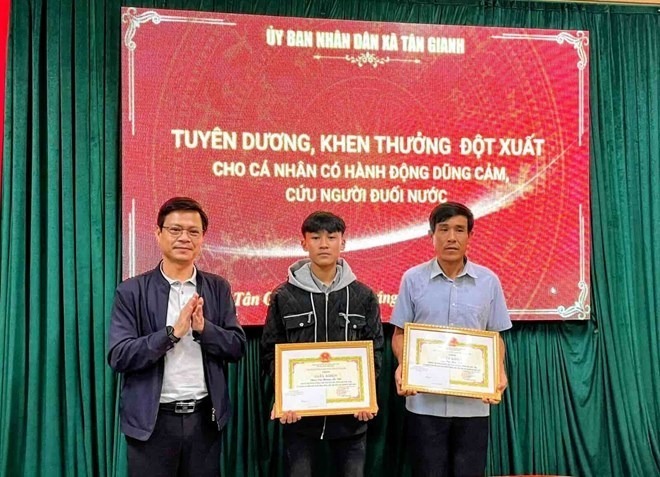 Lãnh đạo xã Tân Gianh khen thưởng 2 bố con cứu người vụ lật thuyền trên sông Gianh. (Ảnh: UBND xã Tân Gianh)
