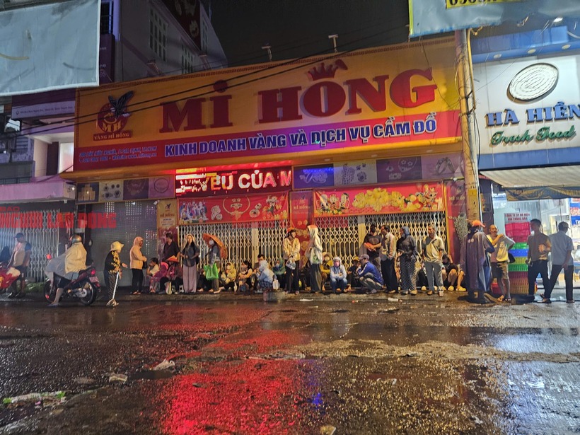 Trong ngày vía Thần Tài (mùng 10 tháng Giêng âm lịch), dù trời TP.HCM mưa khá to nhưng từ 3h sáng nay 26/2, nhiều người dân đã có mặt, xếp hàng dài trước tiệm vàng Mi Hồng (nằm ngay khu vực chợ Bà Chiểu) chờ đến giờ mở cửa để mua vàng. (Ảnh: Người lao động)