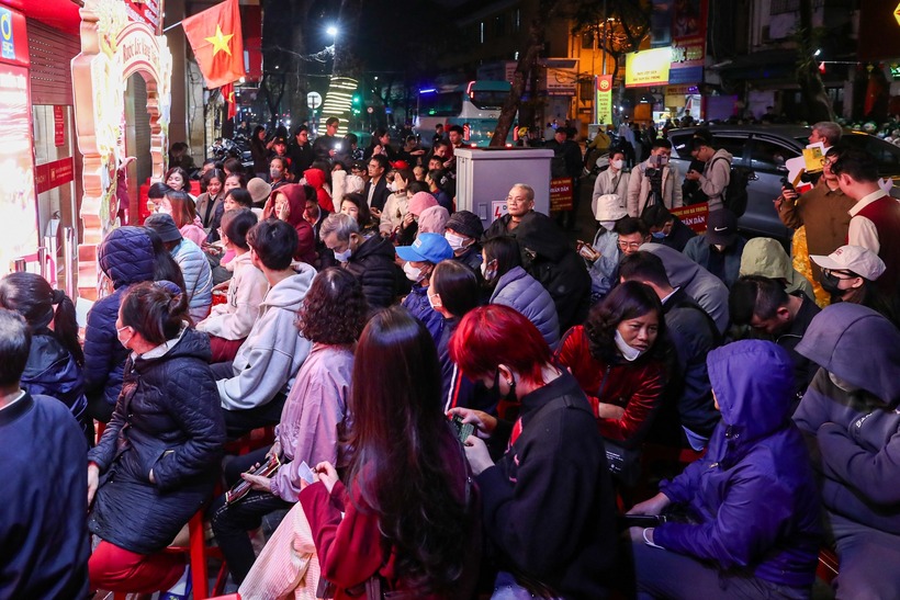 Vào sáng sớm 26/2, rất đông người dân đã có mặt tại phố vàng Trần Nhân Tông (P.Hai Bà Trưng, Hà Nội), xếp hàng chờ mua vàng lấy may. Thậm chí, dù nhiều thời điểm có mưa nhưng họ vẫn xếp hàng dài trên vỉa hè, kiên nhẫn đợi đến lượt mua vàng. (Ảnh: Thanh niên)