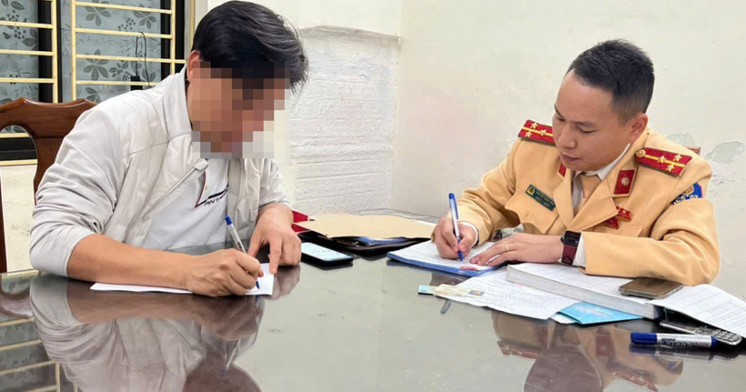 CSGT làm việc với tài xế vừa bế trẻ nhỏ vừa điều khiển ô tô.