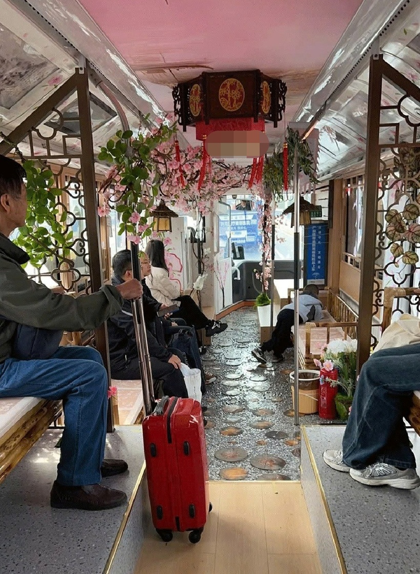 Không gian bên trong xe cũng được "hô biến" với khung cửa gỗ chạm khắc, đèn lồng, hoa nhựa và ghế tre. Ảnh: Sixthtone.