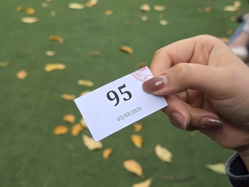 Một phụ huynh nhận được số thứ tự nộp hồ sơ vào lớp 10 Trường THPT Phan Bội Châu trong sáng 3/3. Ảnh: Sức khỏe & Đời sống