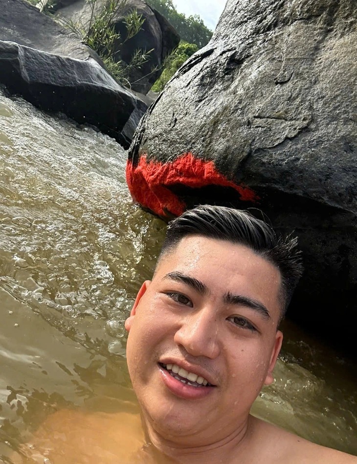 Người dân chụp ảnh "check - in" bên tảng đá nổi màu đỏ. Ảnh: Tuổi trẻ Online