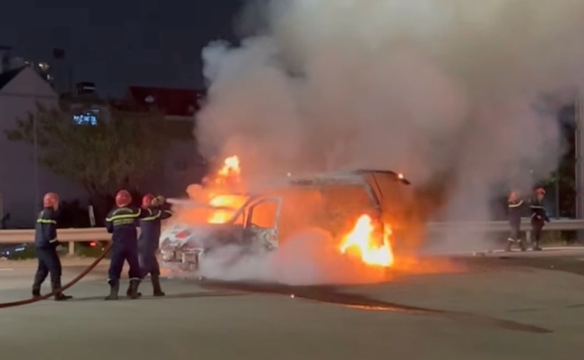 Lính cứu hỏa kéo vòi rồng dập lửa ôtô cháy. (Ảnh: VnExpress)