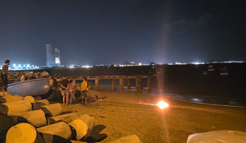 Người thân đốt lửa bên bờ chờ tin bé trai. Ảnh: PLO.