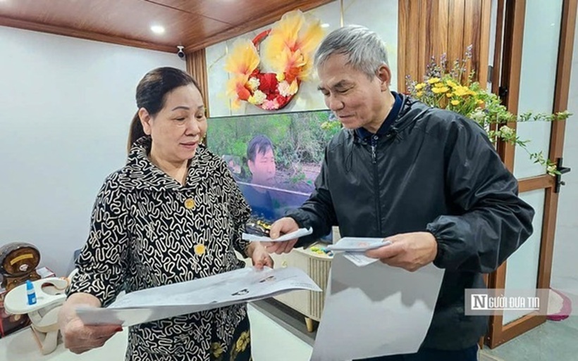 Người dân nhận thẻ cử tri từ cán bộ tổ dân phố (Ảnh: Hữu Thắng).