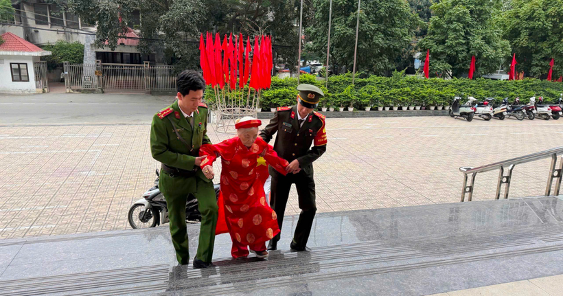 Hình ảnh cán bộ, chiến sĩ công an phường Đống Đa tận tình dìu đỡ cử tri cao tuổi đi bầu cử.