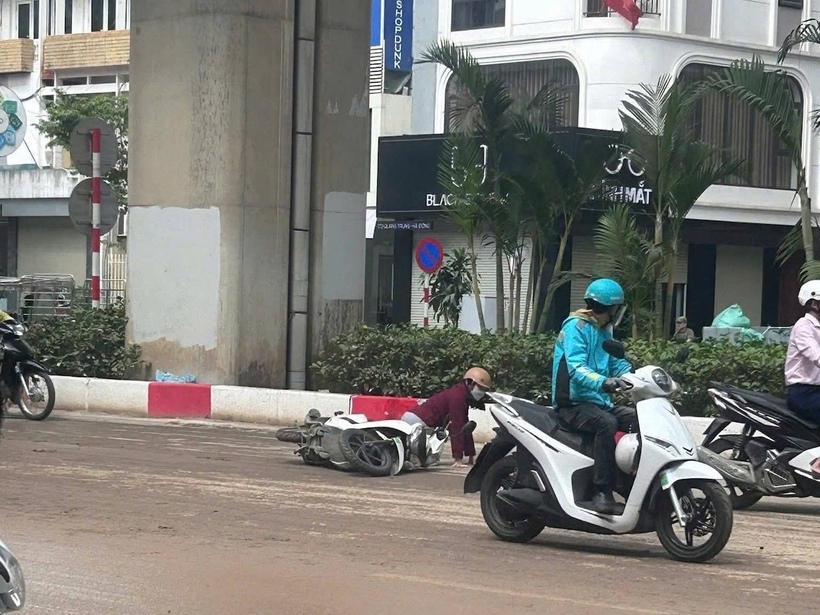 Nhiều tài xế xe máy trượt ngã do lớp bùn lầy gây trơn trượt trên mặt đường