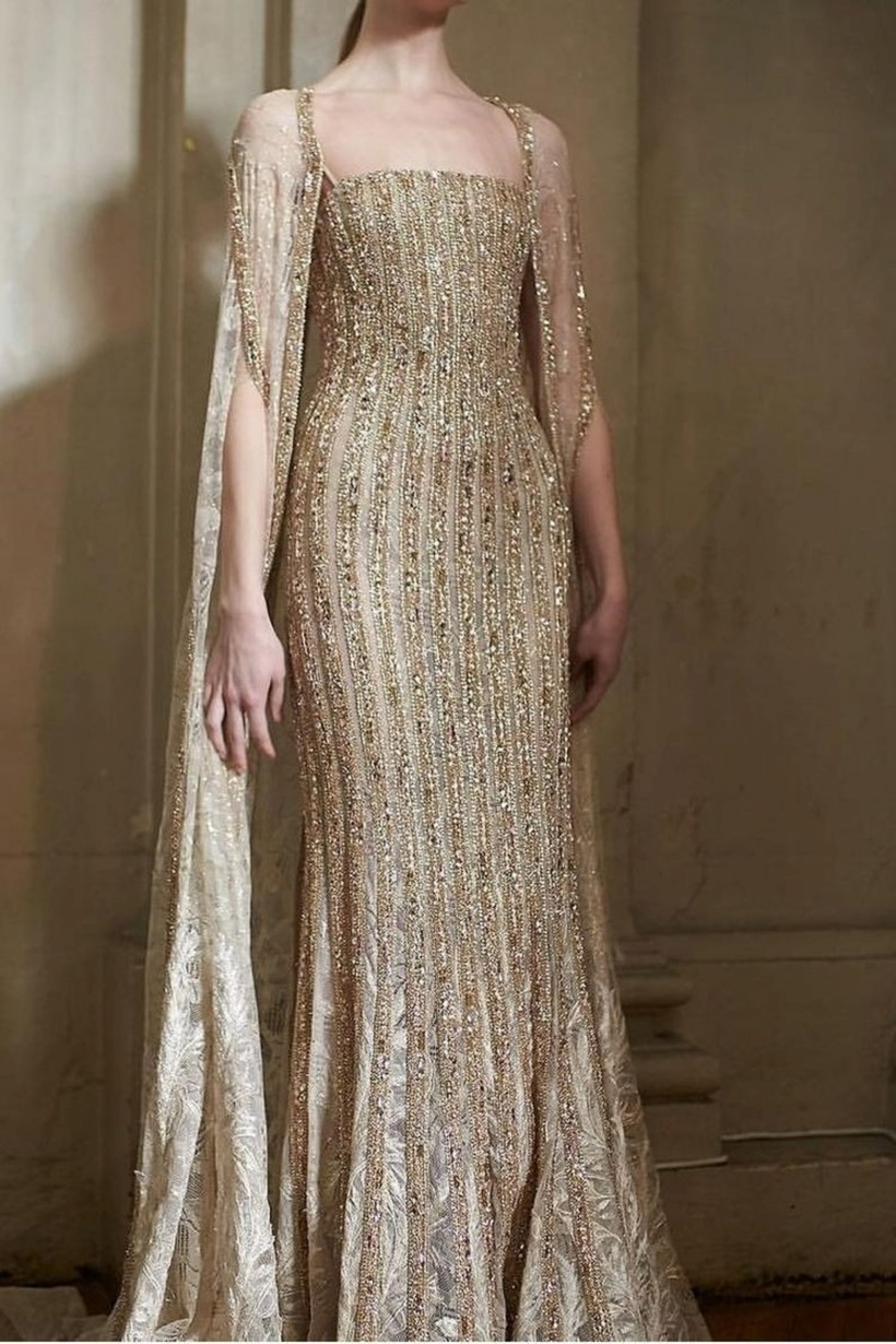 Váy Cape phần vải choàng nhẹ từ vai xuống tạo cảm giác quyền quý như các nữ hoàng. Mẫu này rất phù hợp để che khuyết điểm bắp tay to.