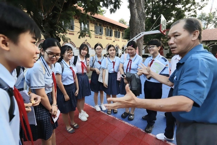 Học sinh Trường THCS Quang Trung đang được giáo viên dặn dò trước khi thi tại điểm thi Trường THPT Marie Curie. Ảnh: Tuổi Trẻ.