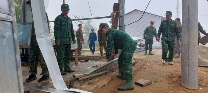 Cán bộ, chiến sĩ Đồn biên phòng Pa Ủ hỗ trợ người dân sửa chữa nhà cửa sau dông lốc. (Ảnh: Tuổi trẻ)