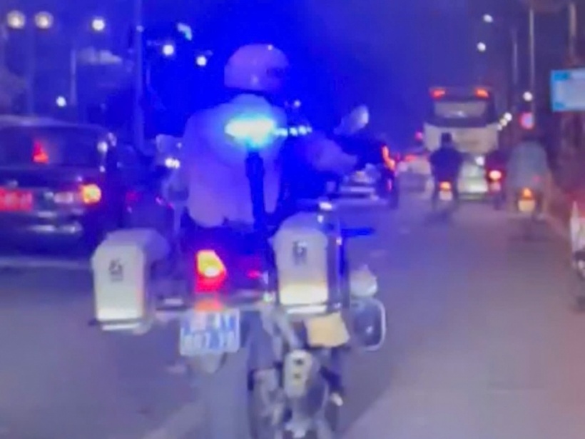 Thượng uý Sơn dùng xe chuyên dụng mở đường cho xe chở cháu bé bị nạn đi cấp cứu. (Ảnh: Công an nhân dân)