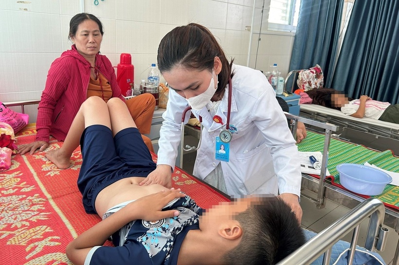 Bác sĩ kiểm tra sức khỏe cho bệnh nhi nghi ngộ độc thực phẩm sau khi ăn bánh mì. Ảnh: Người Lao Động.