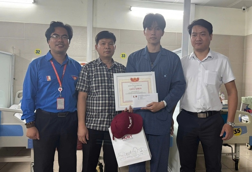 Đoàn công tác của ĐH Bách khoa Hà Nội đến bệnh viện thăm, tặng quà và giấy khen cho Tú. Ảnh: HUST