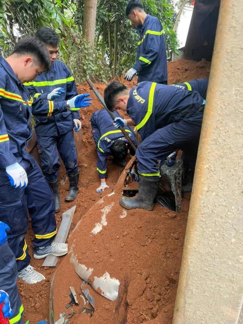 Lực lượng Cảnh sát cứu hộ các nạn nhân bị vùi lấp dưới khối lượng lớn đất trên thùng xe tải trút xuống. (Ảnh: Dân trí)