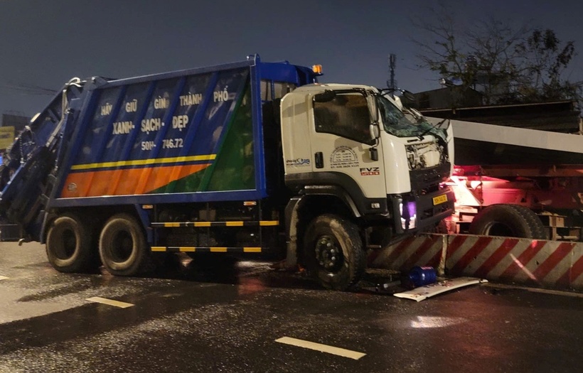 Tấm thép rơi xuống đè bẹp cabin xe rác. Tài xế xe rác được đưa đi cấp cứu nhưng không qua khỏi do thương tích nặng. (Ảnh: VietnamNet)