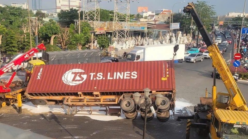 Hàng loạt thùng sơn bên trong đổ tràn xuống, tạo thành những mảng màu trắng xóa loang lổ trên mặt đường. Ảnh: Vietnamnet.