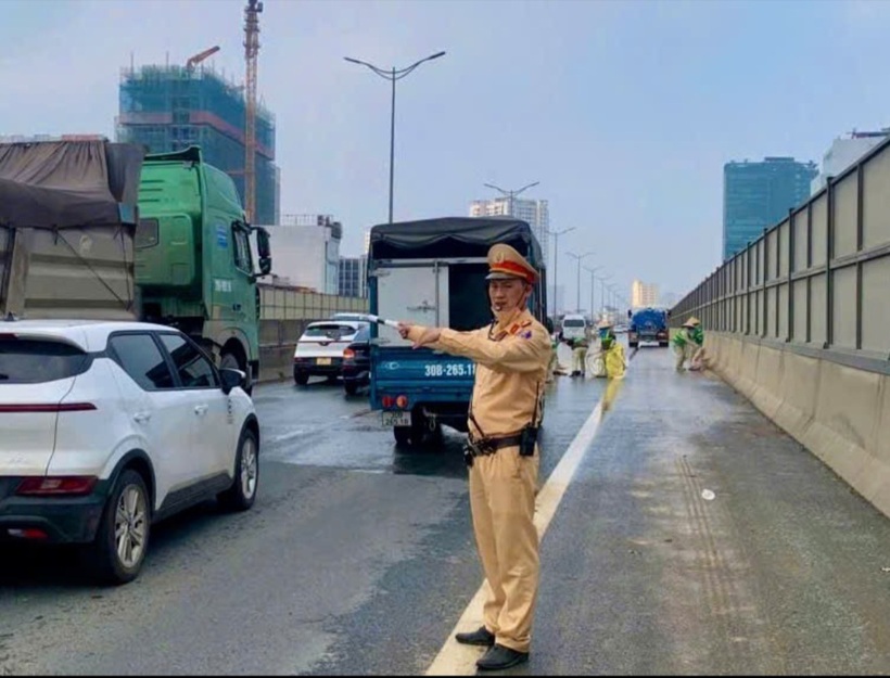 Cảnh sát phân luồng giao thông bảo đảm cho các phương tiện lưu thông qua vị trí đất rơi.