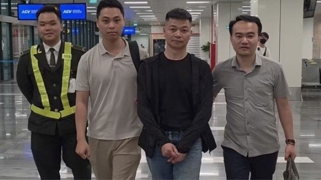 Bắt giữ Nguyễn Tài Minh (áo đen) kẻ chủ mưu đường dây lừa đảo Sky Media đa cấp. Ảnh: Lao động