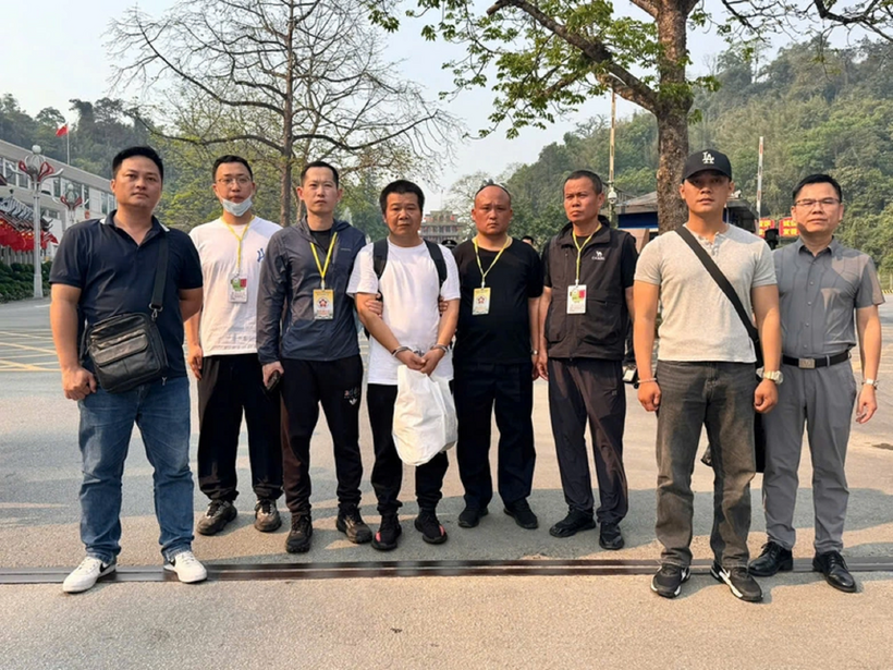 Đối tượng Wang Hua (thứ 4 từ trái qua) được bàn giao cho Trung Quốc sau khi bị Công an Đà Nẵng bắt giữ. Ảnh: Báo Xây Dựng