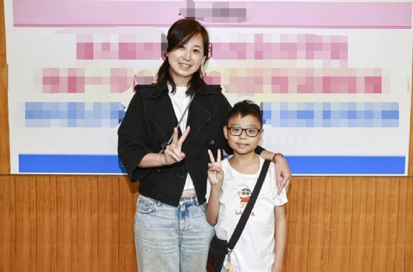 Cậu bé và mẹ tại buổi họp báo ở bệnh viện hôm 15/4. Ảnh: CNA.