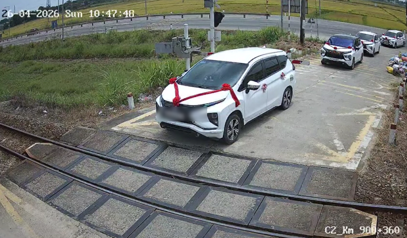 Ô tô đám cưới kẹt giữa gác chắn khi tàu sắp đến. Ảnh: VietNamNet