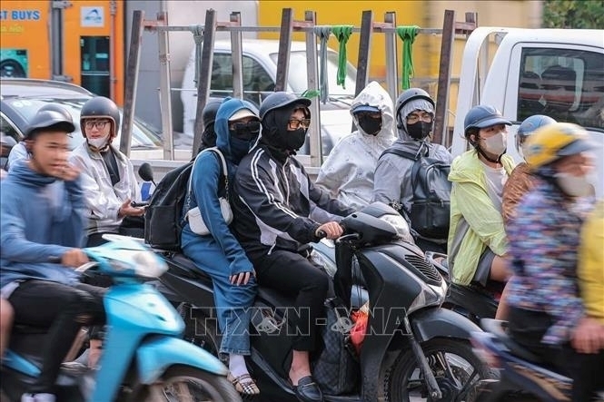 Thời tiết trở nắng gắt khiến việc đi lại lâu ngoài trời vất vả hơn 2 ngày trước đó. Ảnh: TTXVN