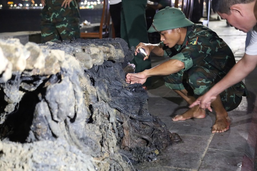 Lực lượng chức năng tìm kiếm, thu thập những hiện vận, súng đạn còn sót lại trong xác xe tăng. (Ảnh: Thanh niên)